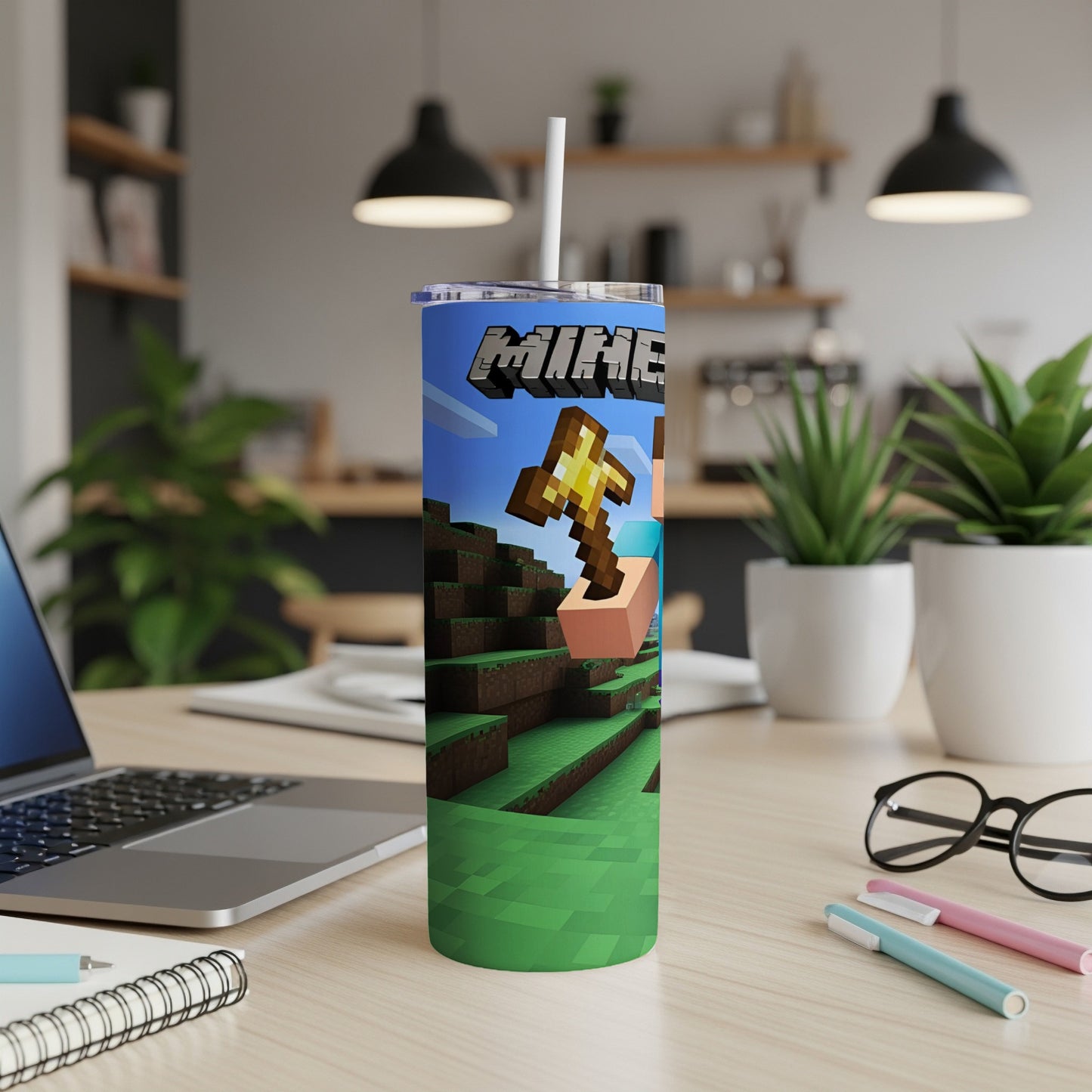 Minecraft tumbler with Creeper character and golden pickaxe on a desk.