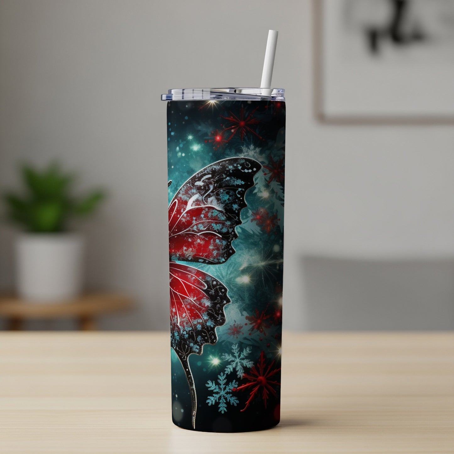 Tumbler with red butterfly wings and snowflakes on a dark background.