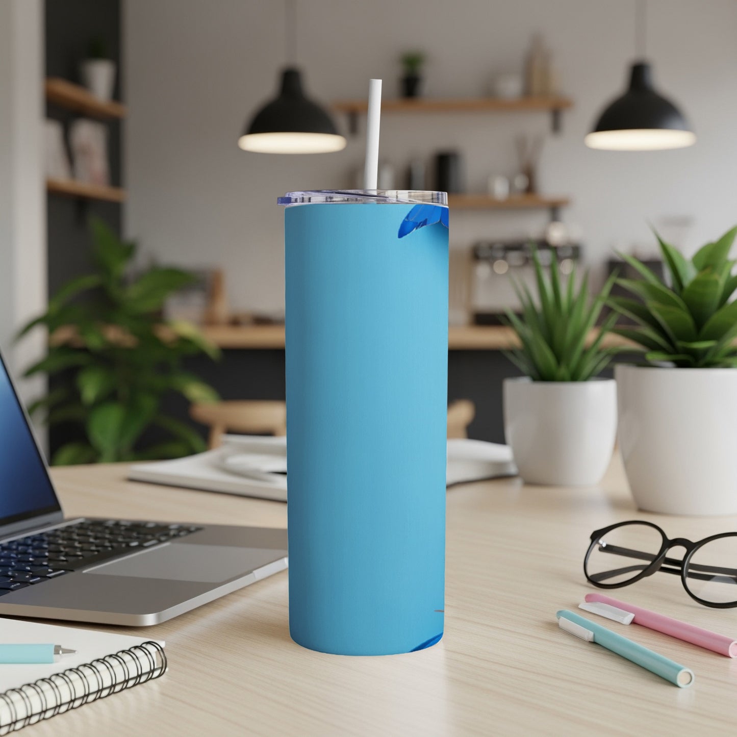 Blue tumbler with a white straw and partial blue leaf graphic.