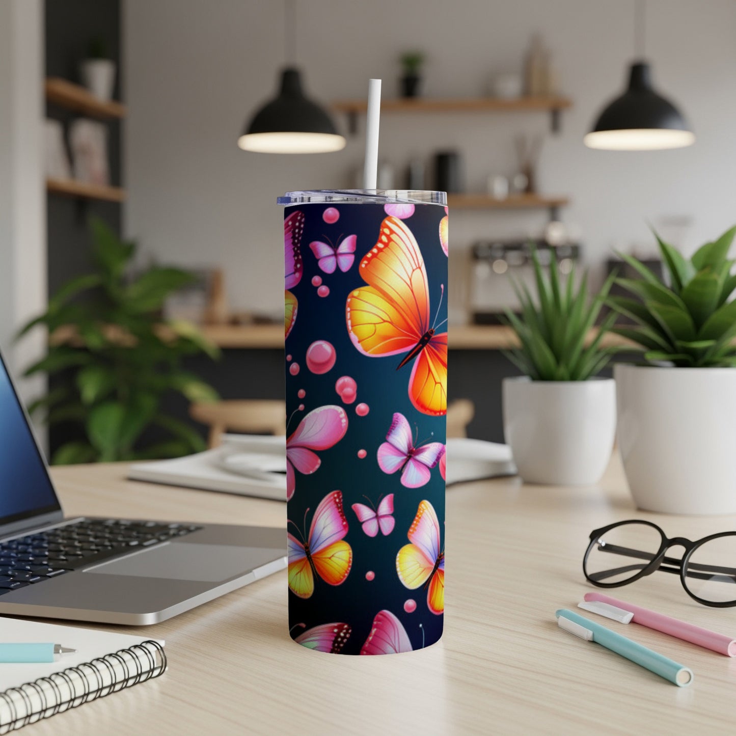 Tumbler with colorful butterflies and pink bubbles on dark background.
