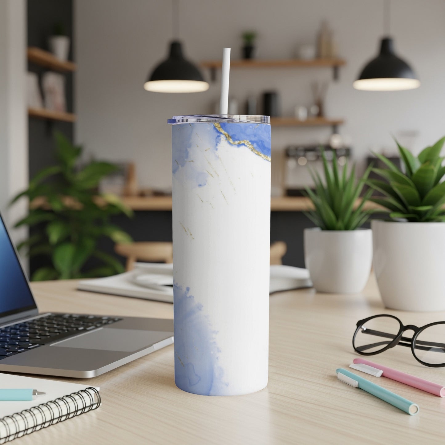 White tumbler with blue marble pattern and gold accents on a desk.