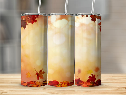 Three tumblers with autumn leaves and bokeh background.