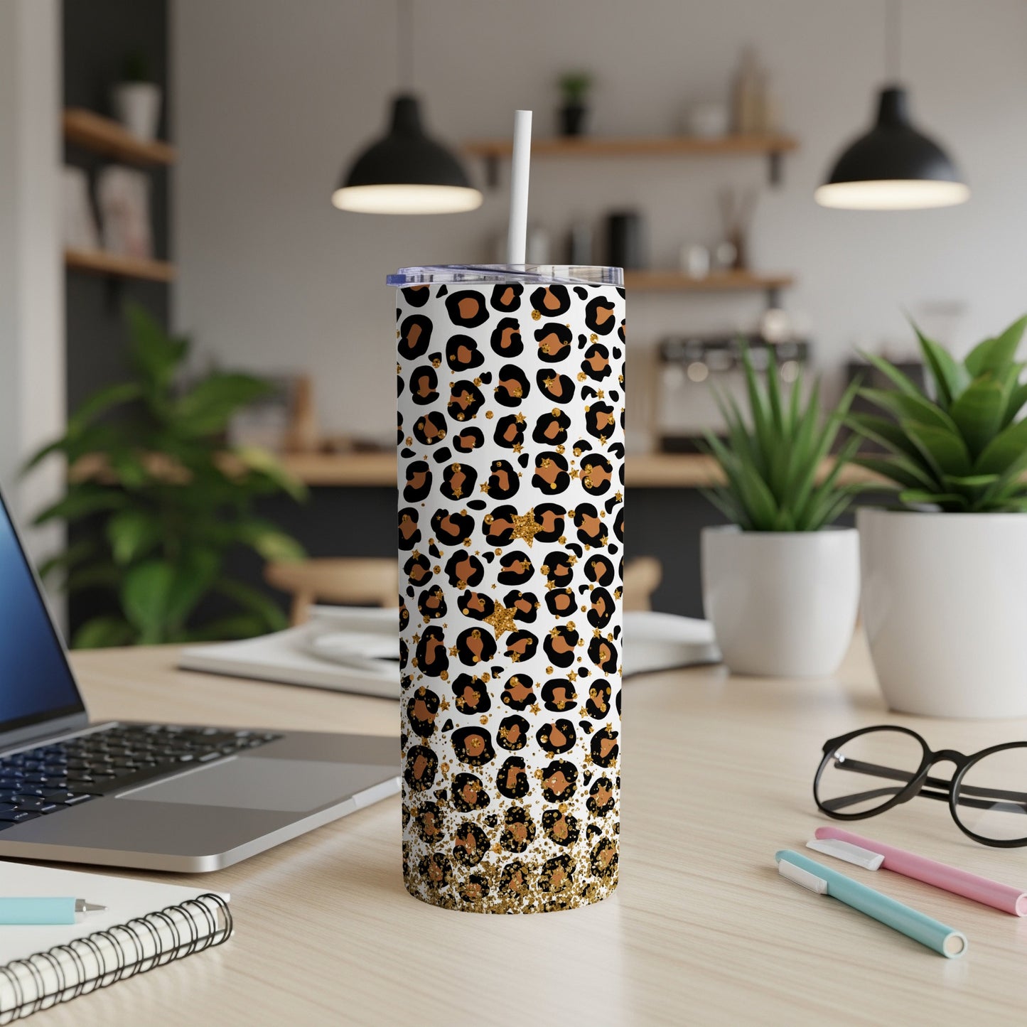 Leopard print skinny tumbler with gold glitter at the base.