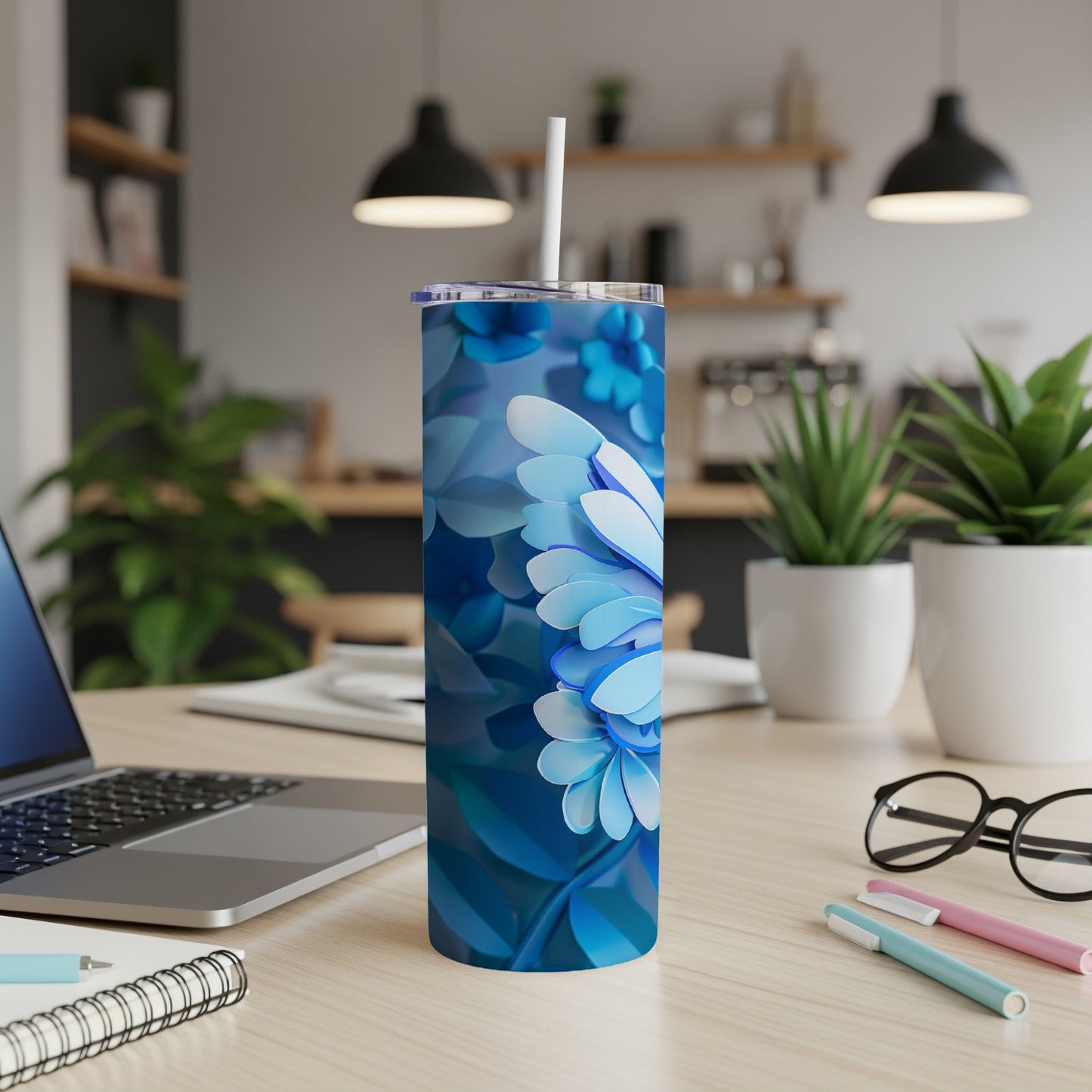 Blue floral tumbler with white straw on a desk.