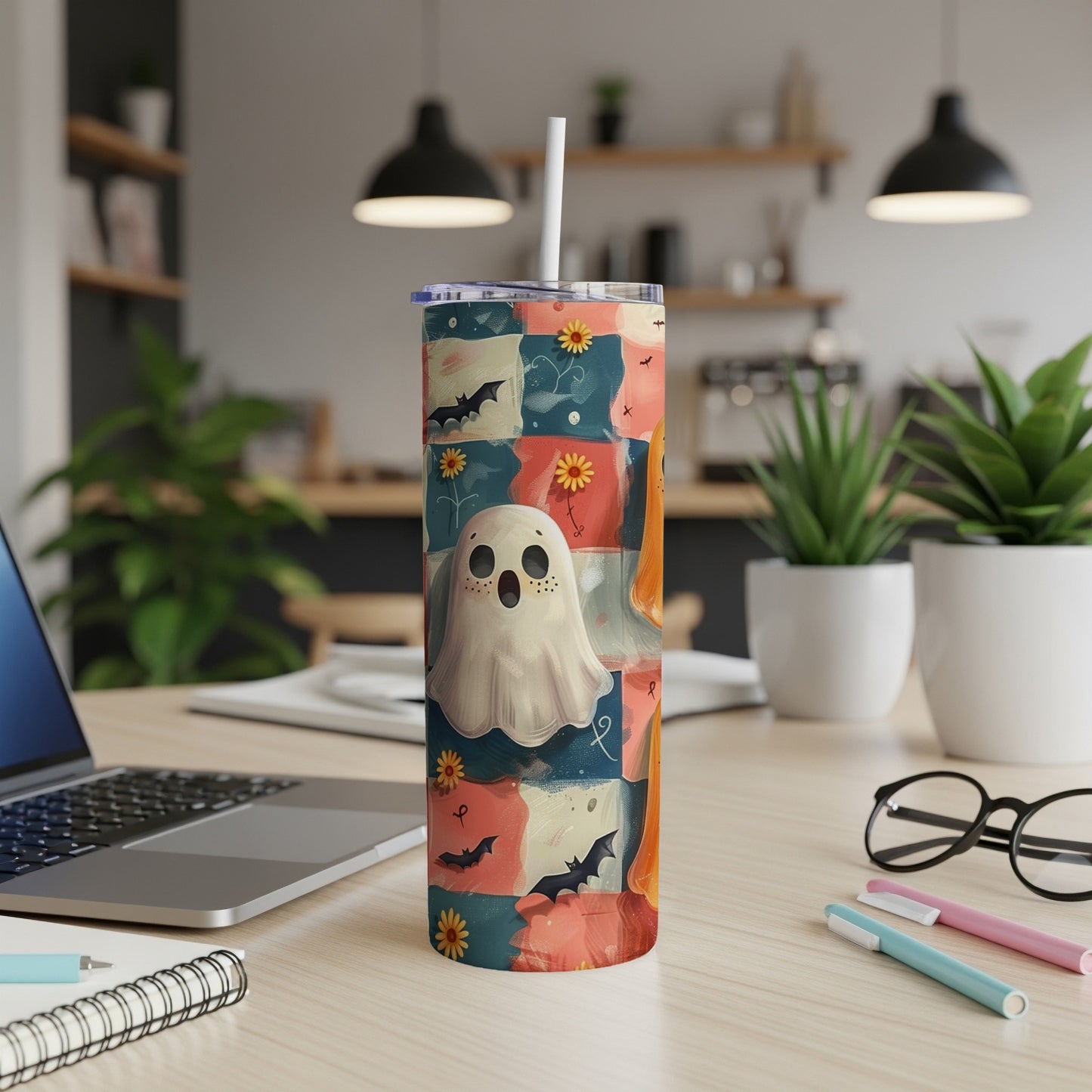 Halloween tumbler with ghost, bats, and flowers on a quilted background.