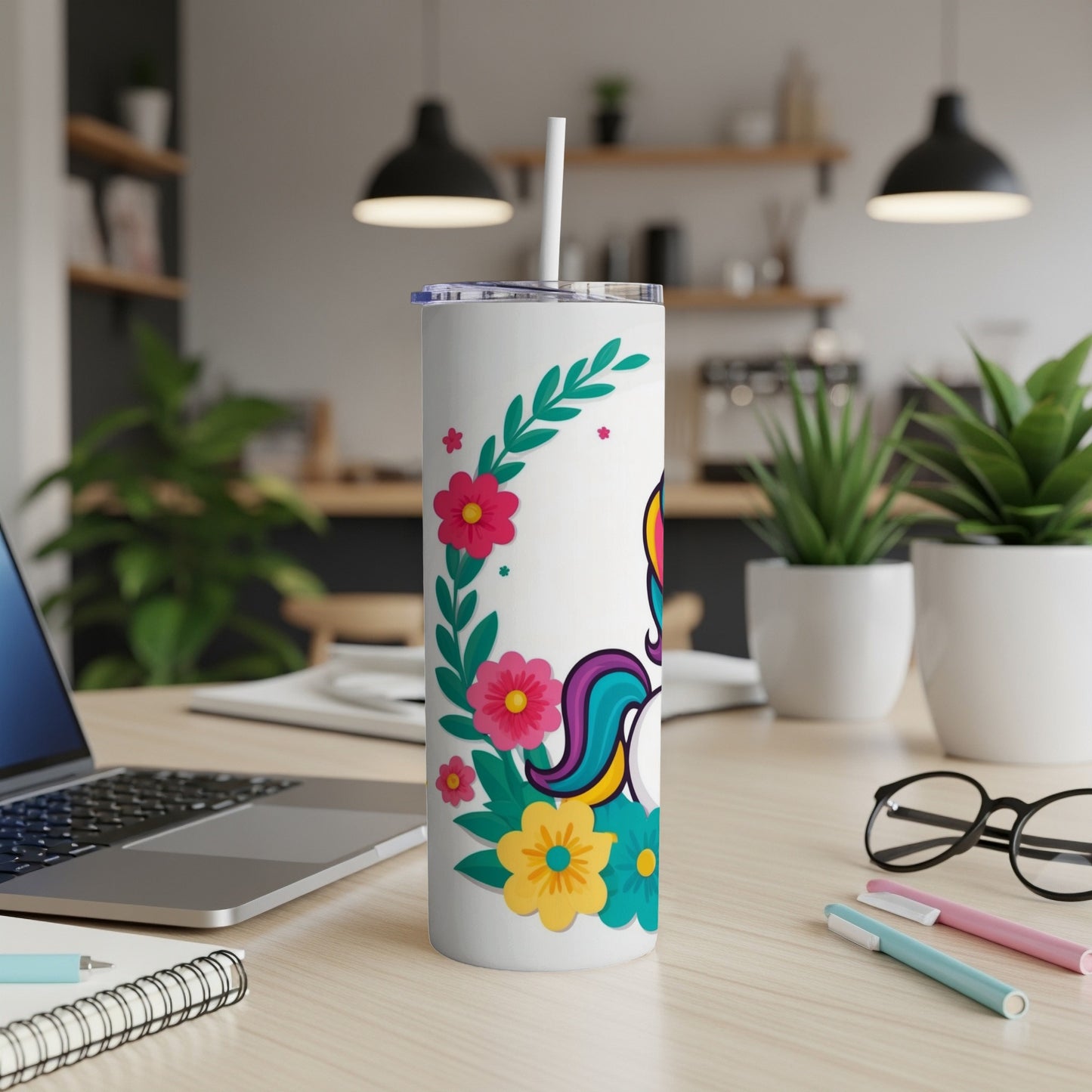 White tumbler with unicorn and floral design, straw inserted.