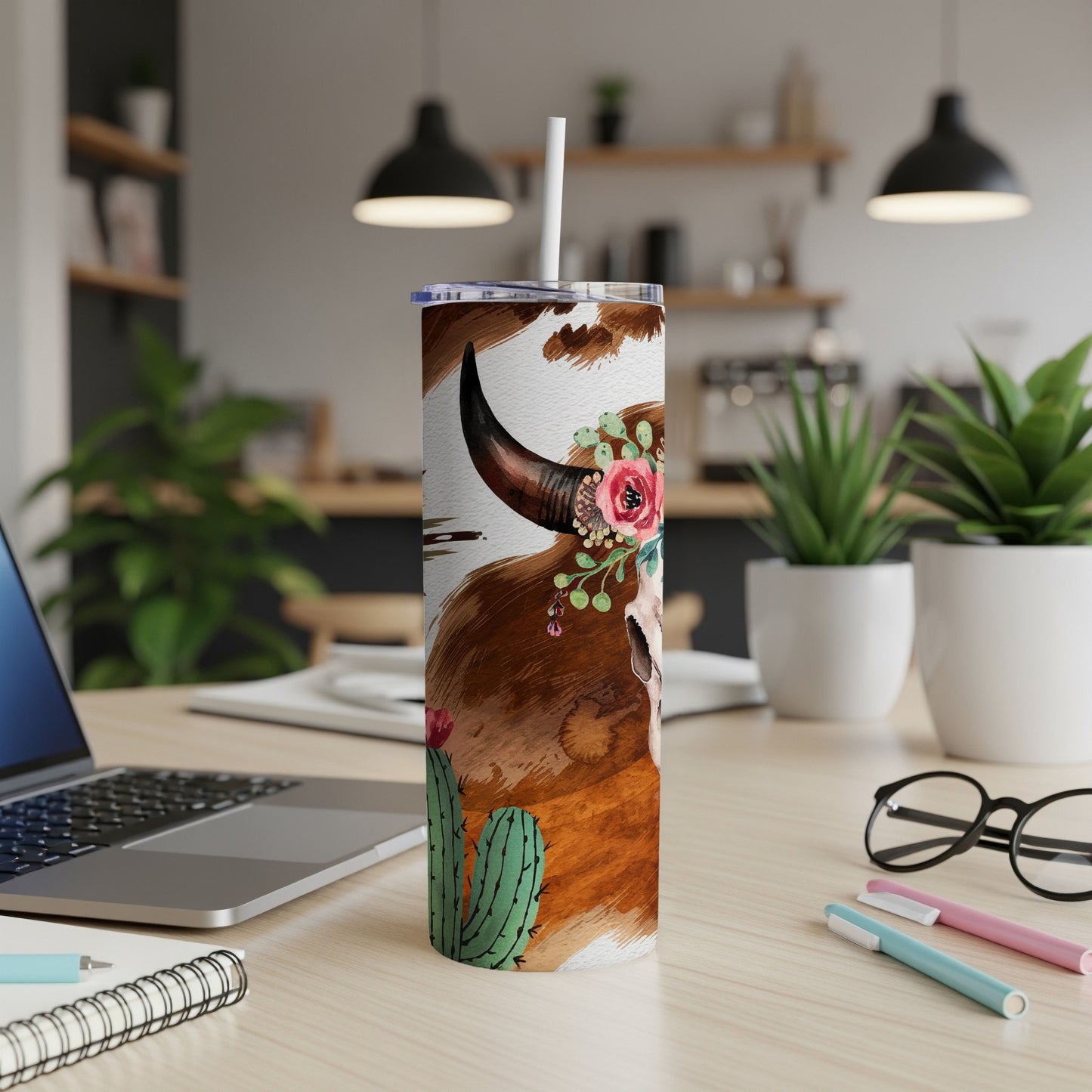 Tall tumbler with cow print, skull, and floral accents.