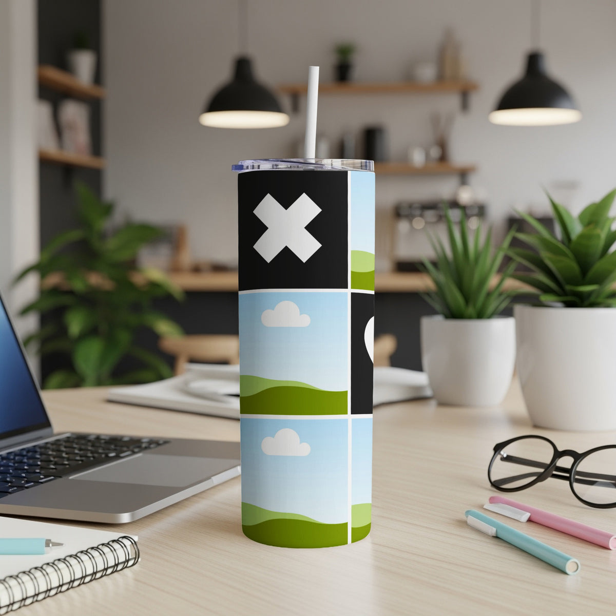 Tumbler with abstract design featuring a large white X, clouds, and green hills.