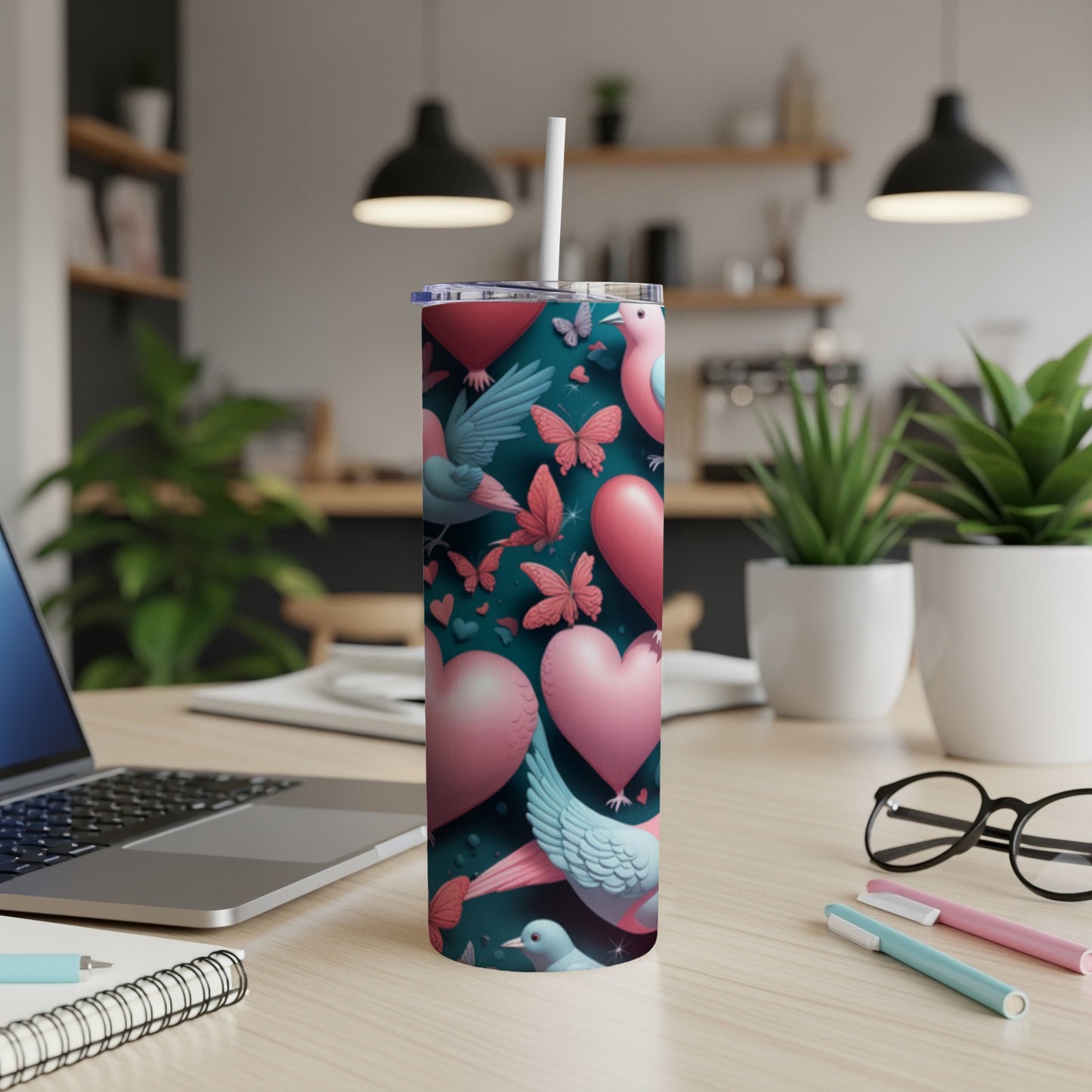 Pink hearts and birds on a teal tumbler with a straw.