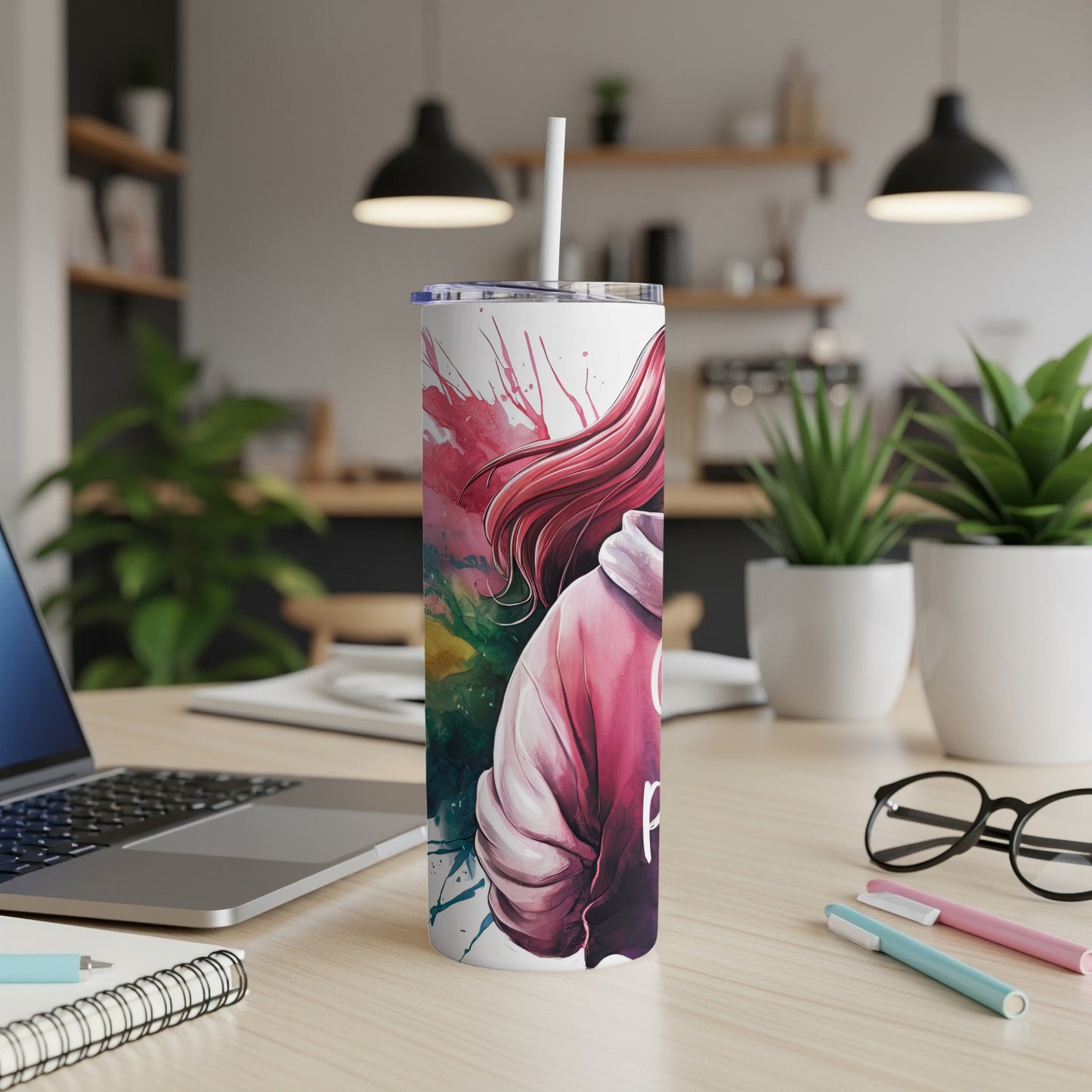 Pink and green abstract art on a white tumbler with a straw.