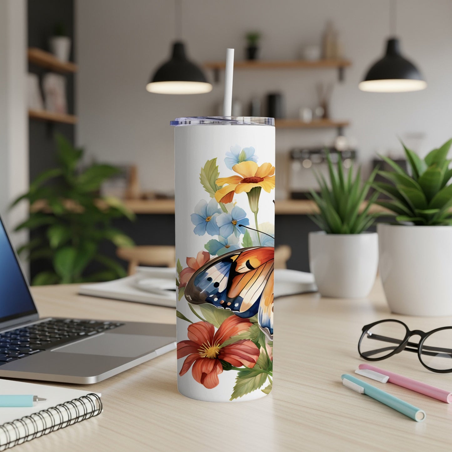 White tumbler with butterfly and floral design, featuring a straw.