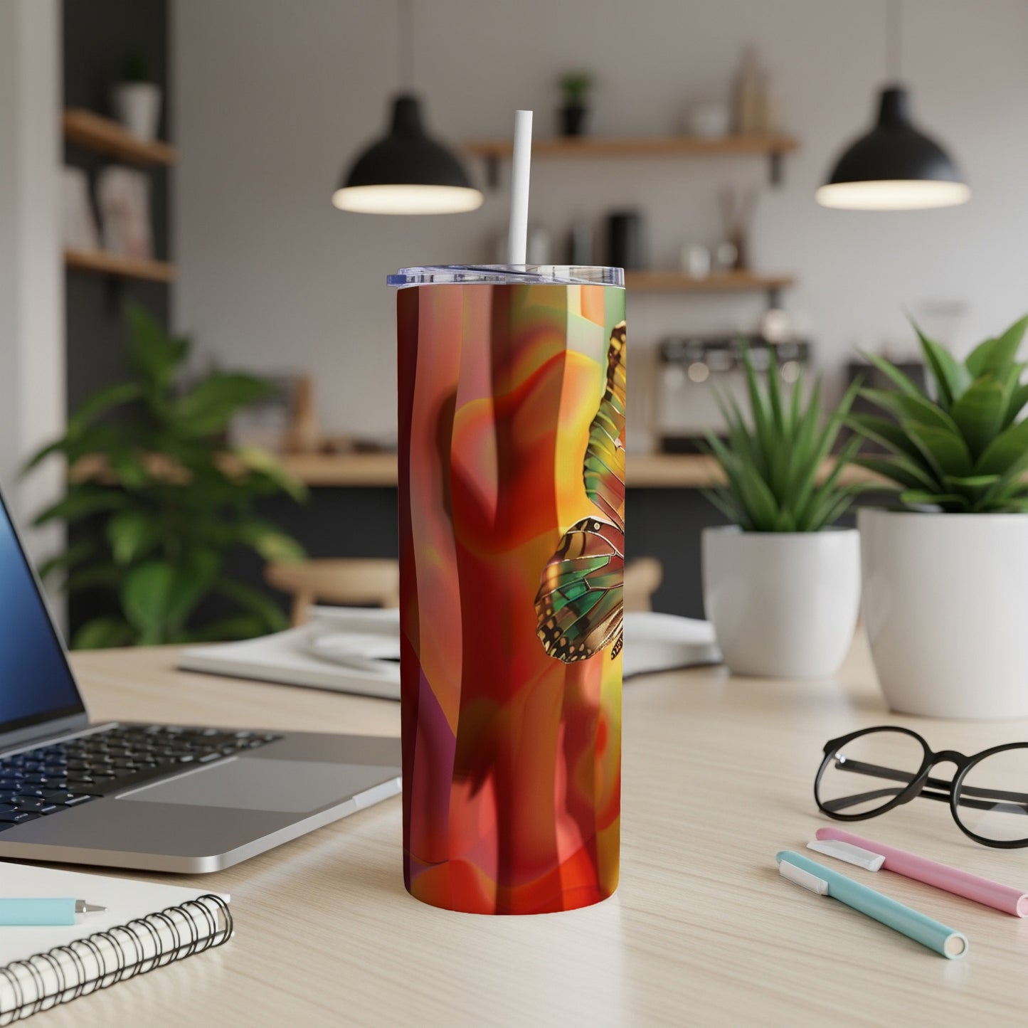 Tumbler with colorful butterfly wings pattern and a white straw.