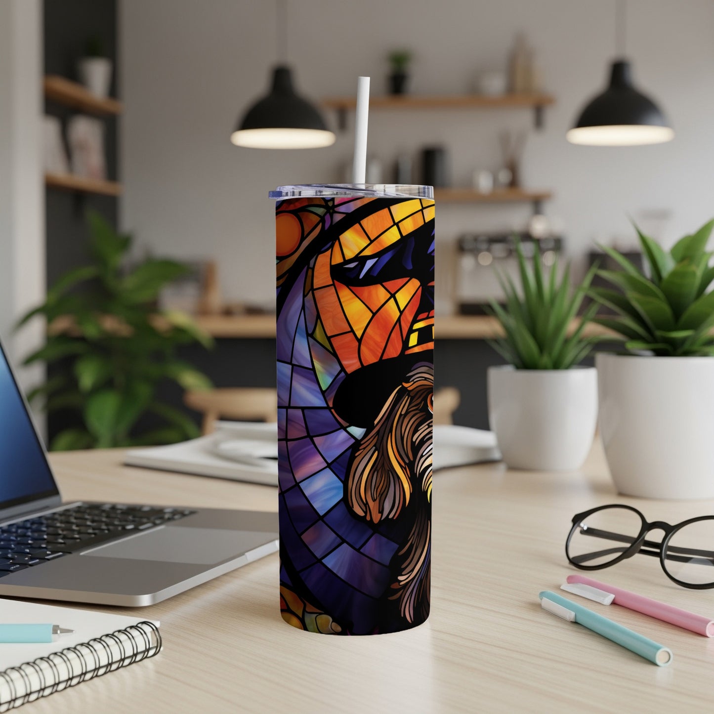 Tall tumbler with a stained-glass lion design on a desk.