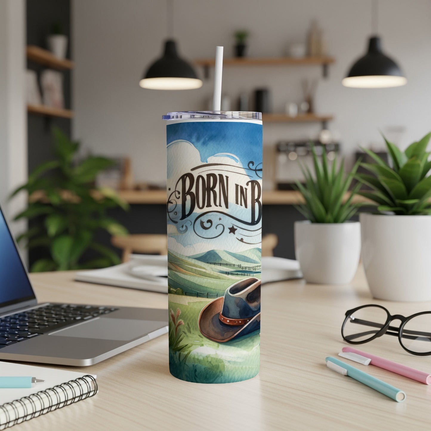 Tall tumbler with cowboy hat, "Born in B" text, and rural landscape design.