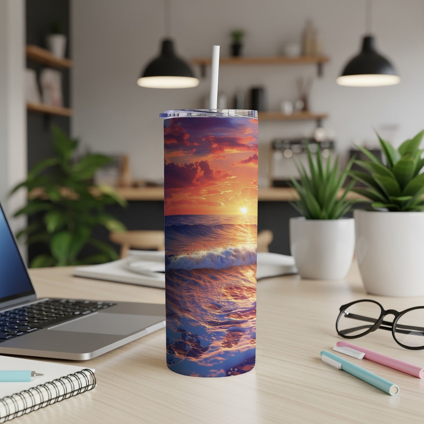 Ocean sunset with waves on a white tumbler with straw on a desk.