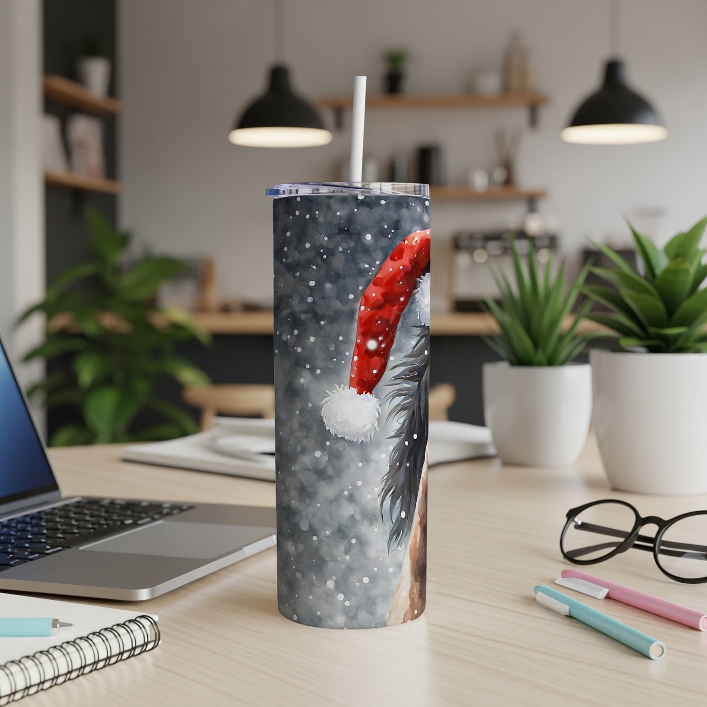 Border Collie wearing a Santa hat on a snowy tumbler with a straw.
