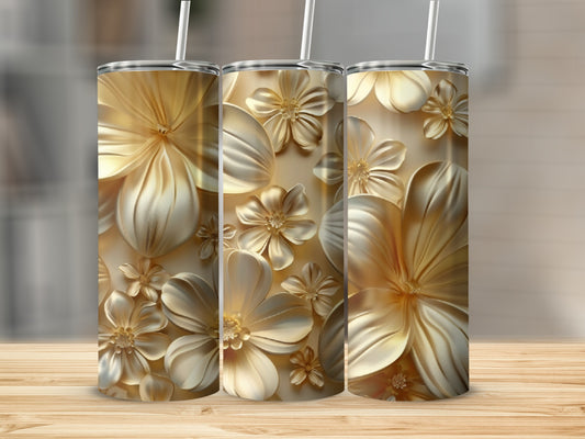 Three gold tumblers with embossed floral designs on a wooden surface.