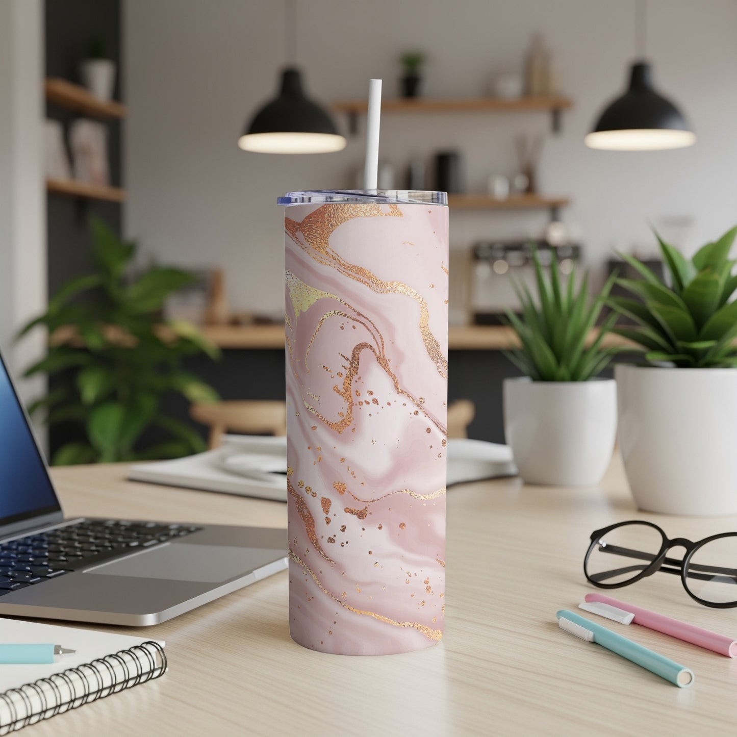 Pink marble pattern tumbler with straw on desk with laptop.