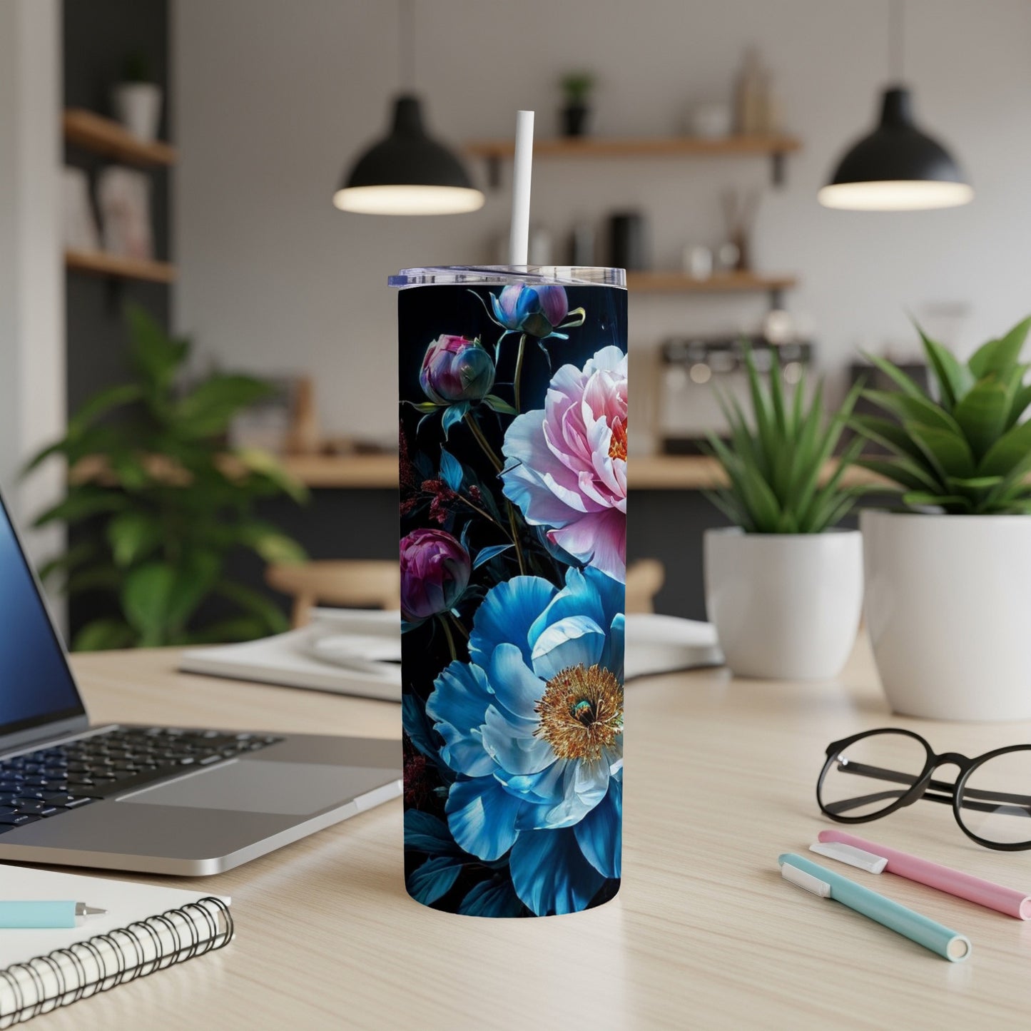 Floral tumbler with pink and blue peonies on a desk with a laptop.