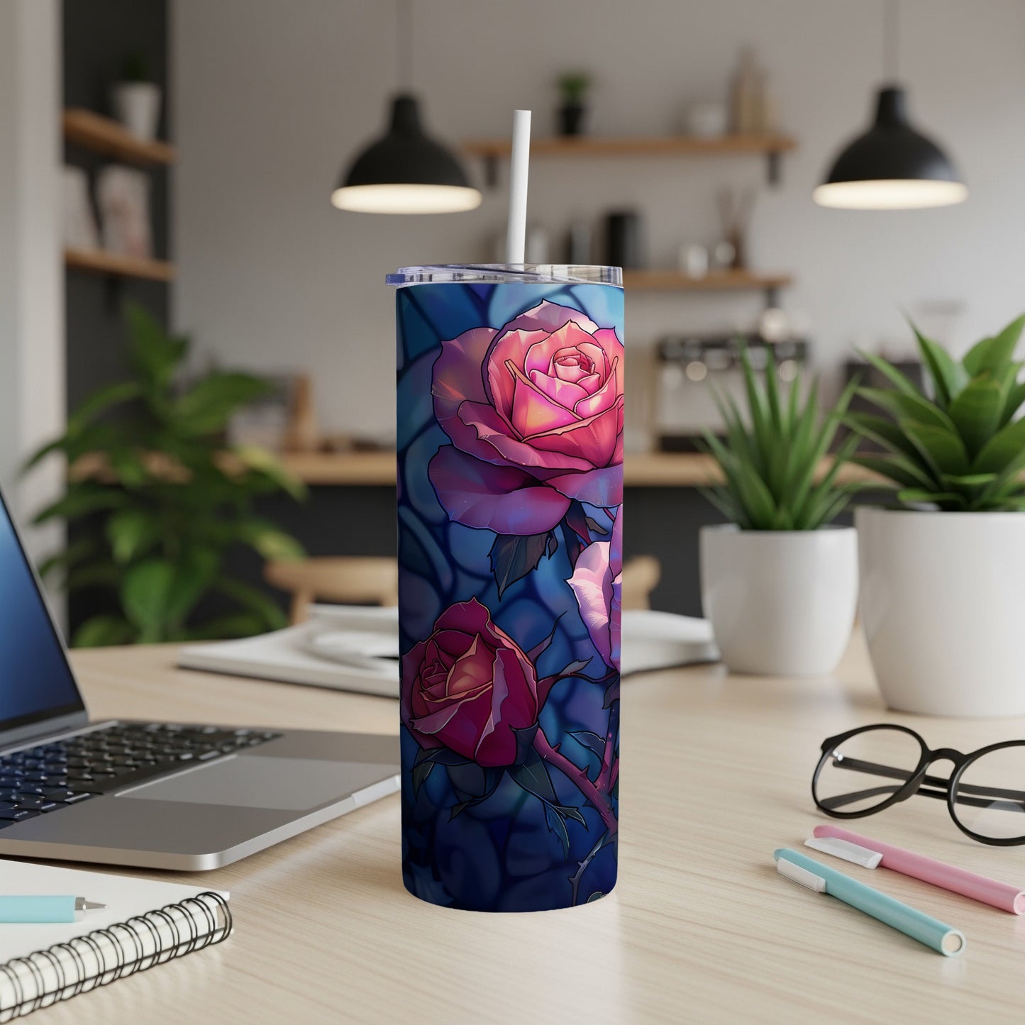 Tumbler with stained glass roses design on a desk.