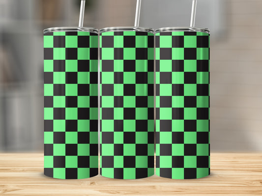 Three green and black checkered tumblers with straws, displayed on a wooden surface.