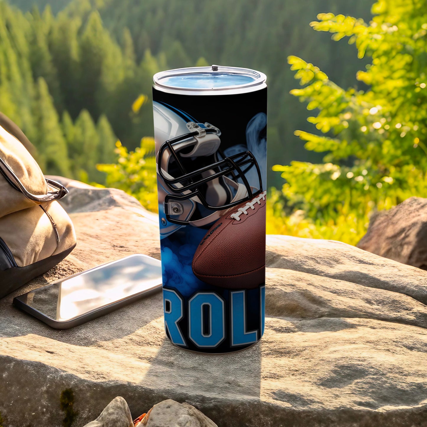 Carolina Panthers football helmet and ball tumbler on rocks outdoors.