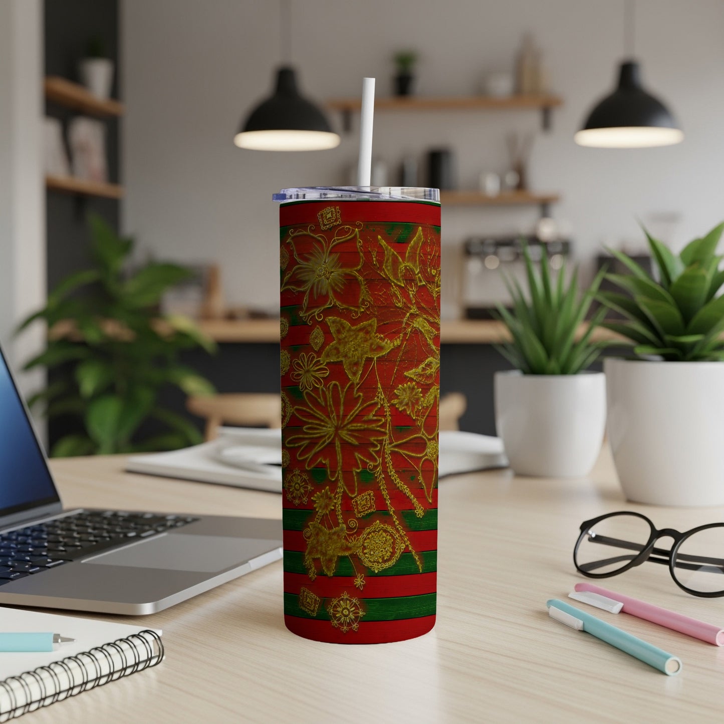 Red tumbler with gold floral pattern and green stripes, straw in lid.