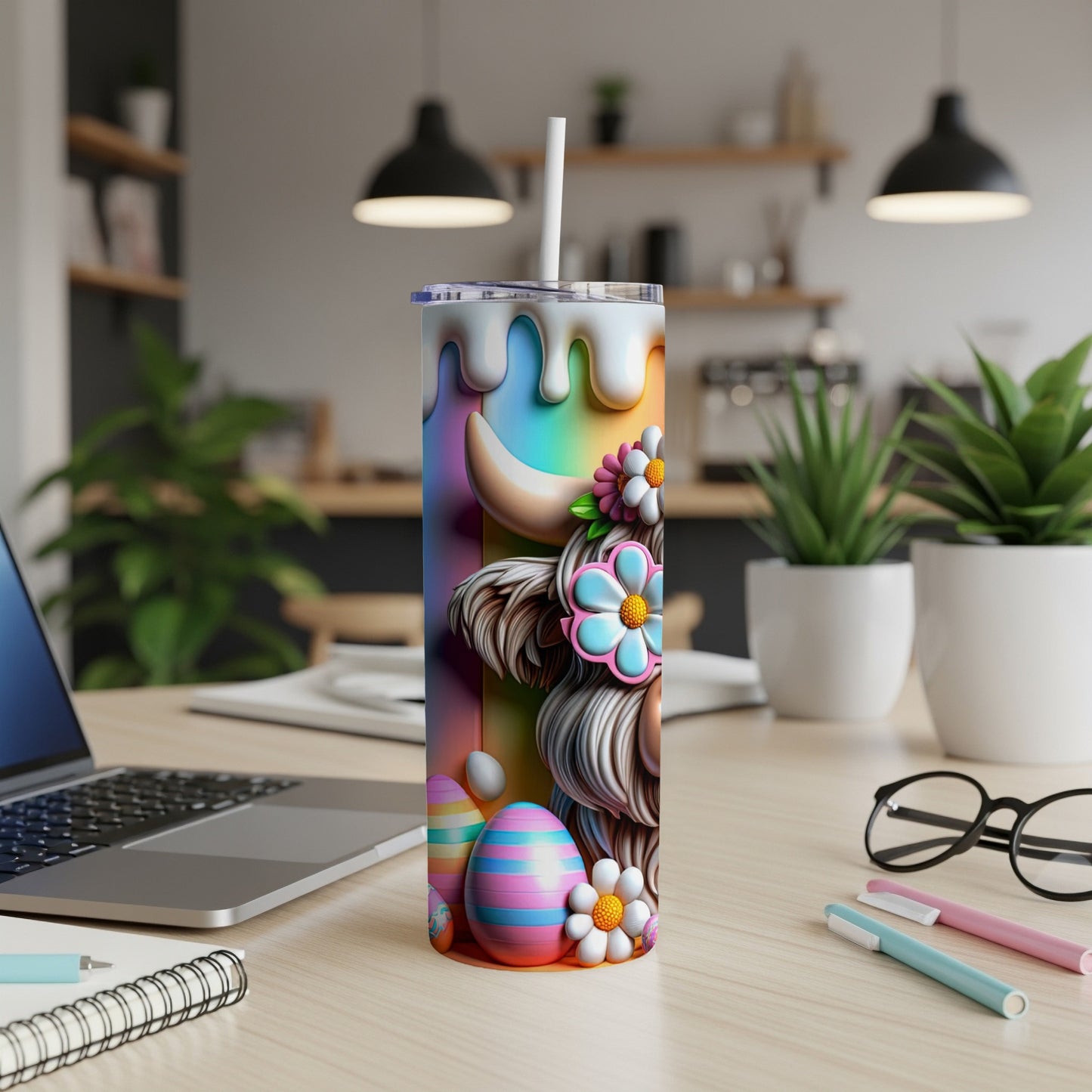 Rainbow cow tumbler with Easter eggs and flowers on a desk.