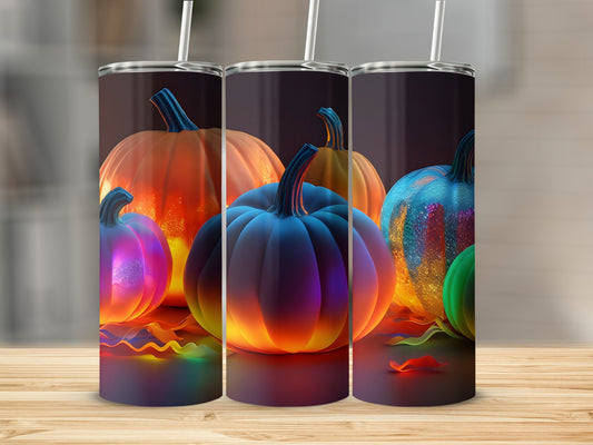 Three glowing, colorful pumpkins with straws on a wooden surface.