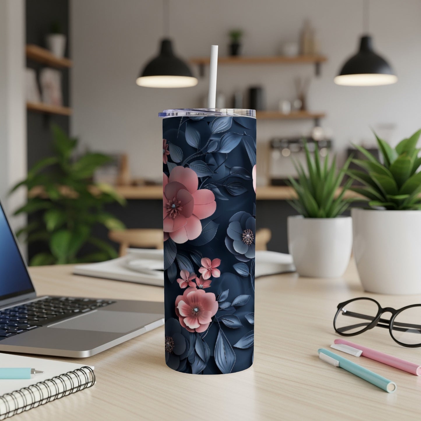Dark navy tumbler with pink and blue floral pattern on a desk.