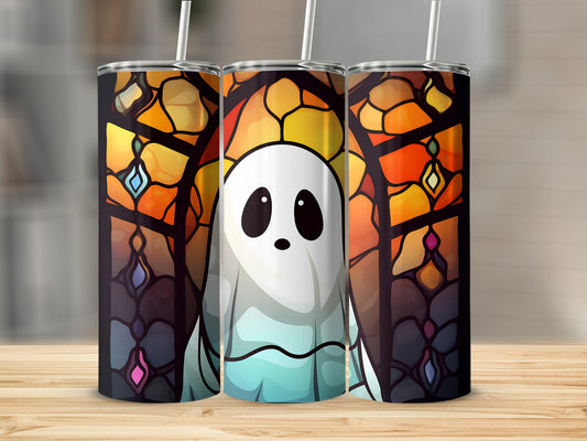 Ghost stained glass tumbler with straw on a wooden surface.