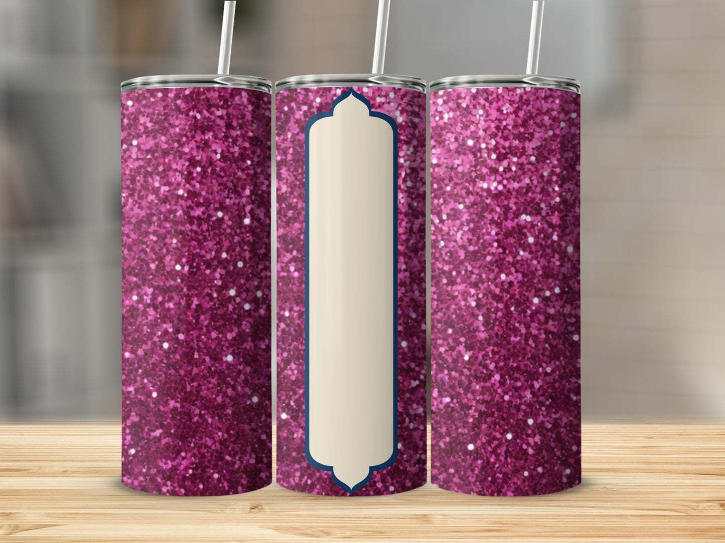 Pink glitter tumbler with cream label on wooden surface.