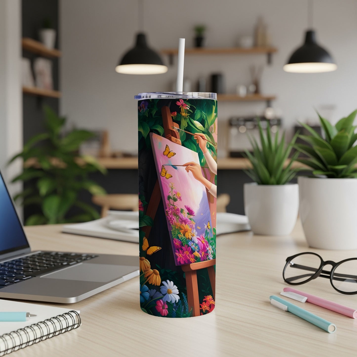 Woman painting a vibrant floral landscape on a tumbler mockup.