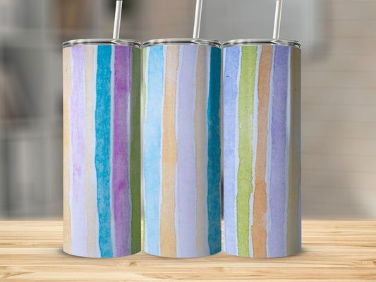 Three tumblers with colorful vertical watercolor stripes on a wooden surface.