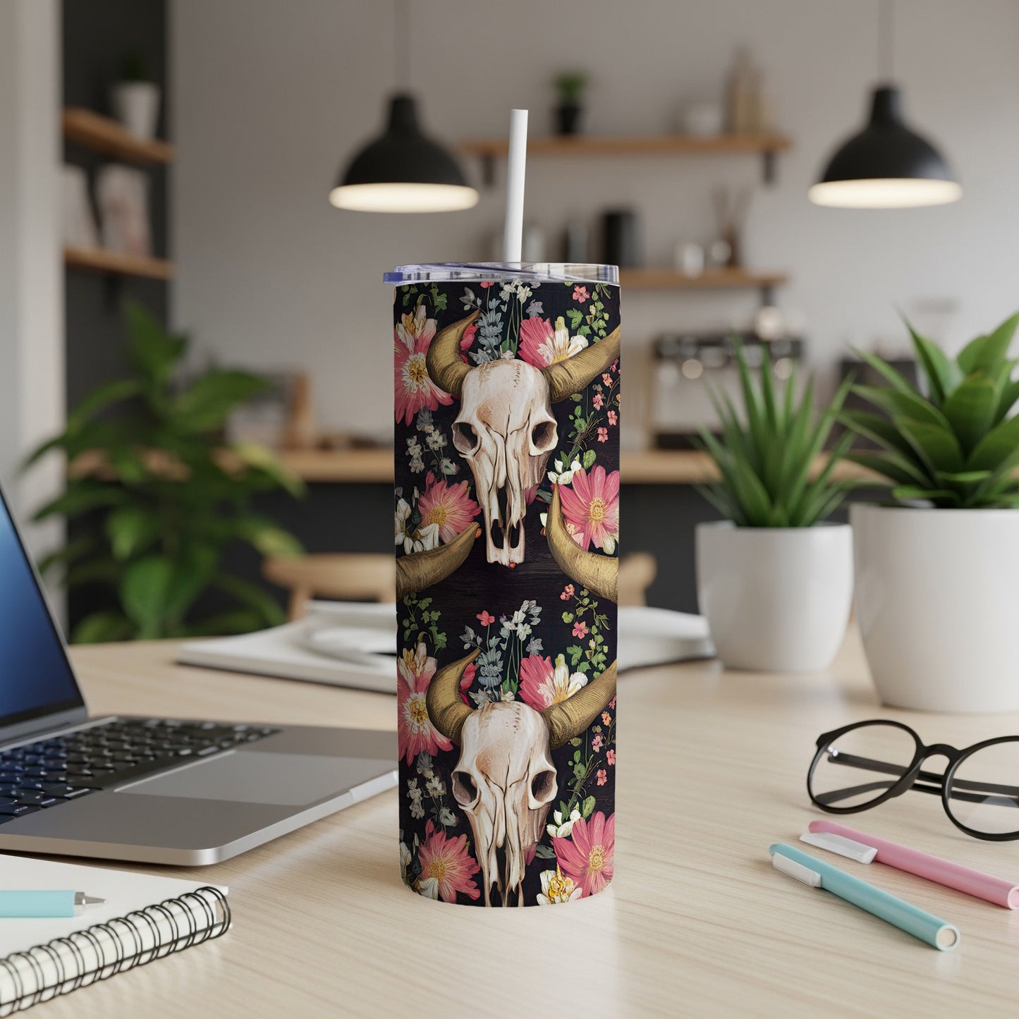 Cow skull with floral pattern on a tumbler with a straw.