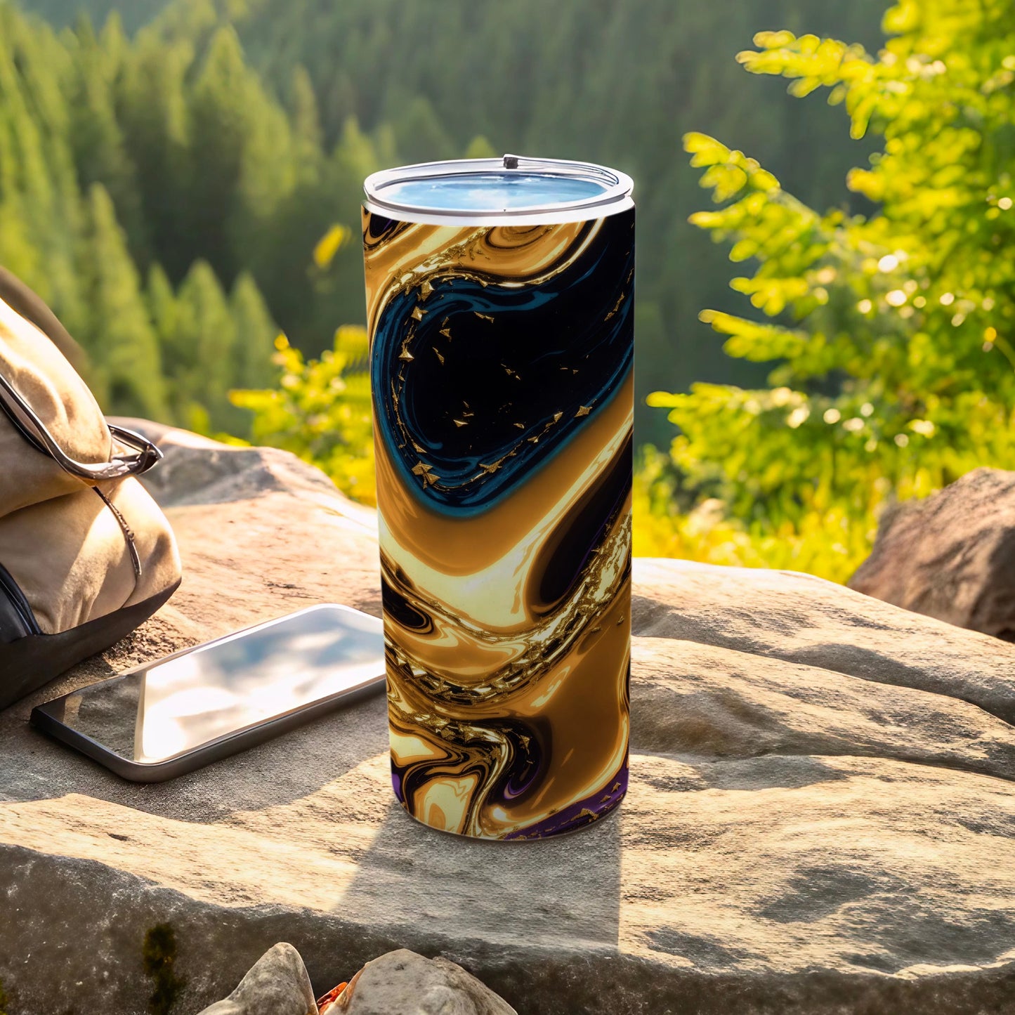 Abstract gold and blue swirling pattern on a tumbler with phone and bag.