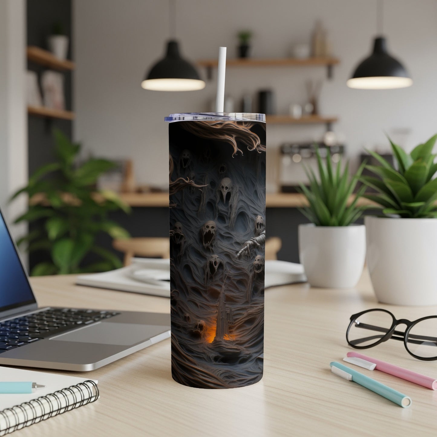 Tumbler with a dark, spooky design of screaming faces and swirling tendrils.
