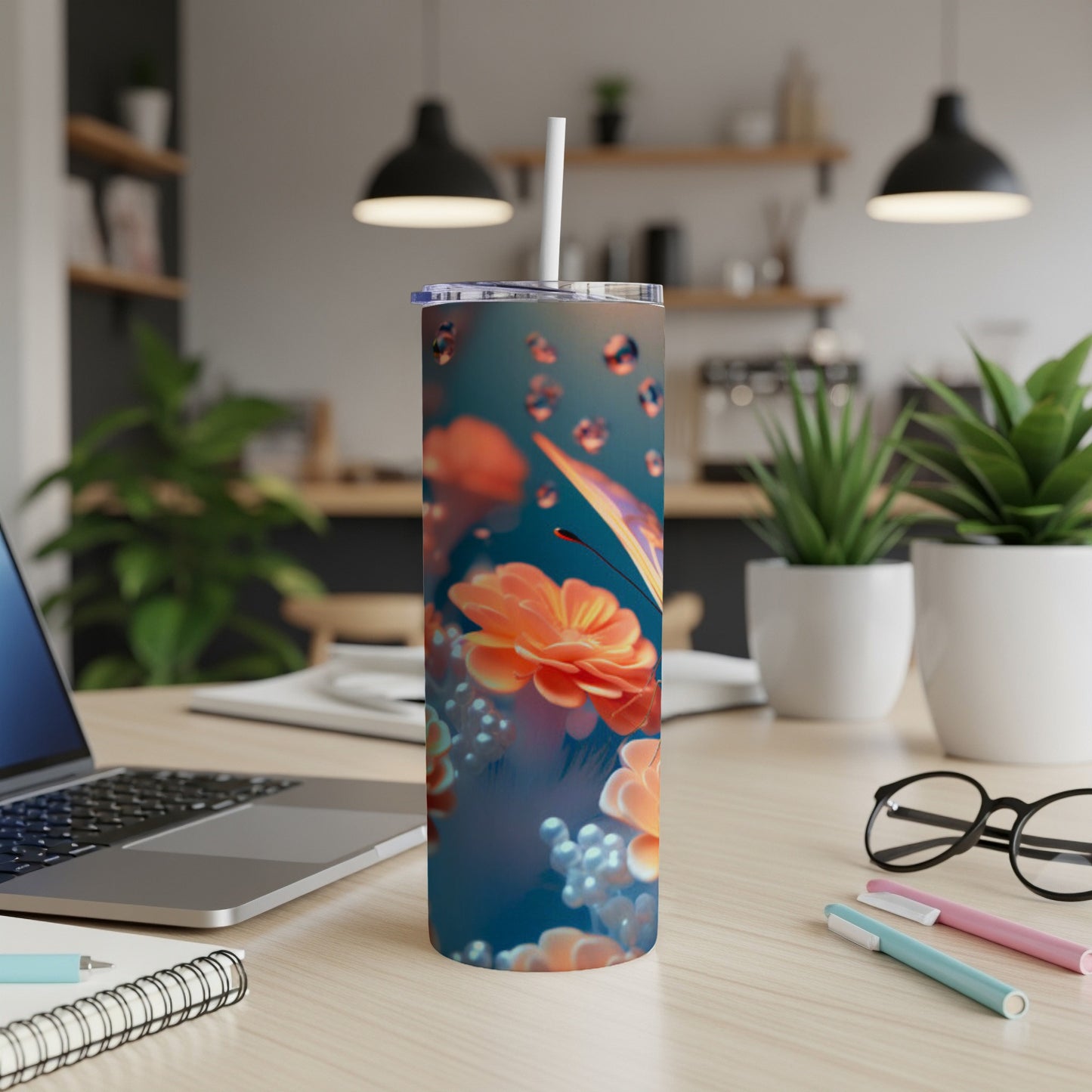 Floral tumbler with butterfly and water droplets, on a desk.