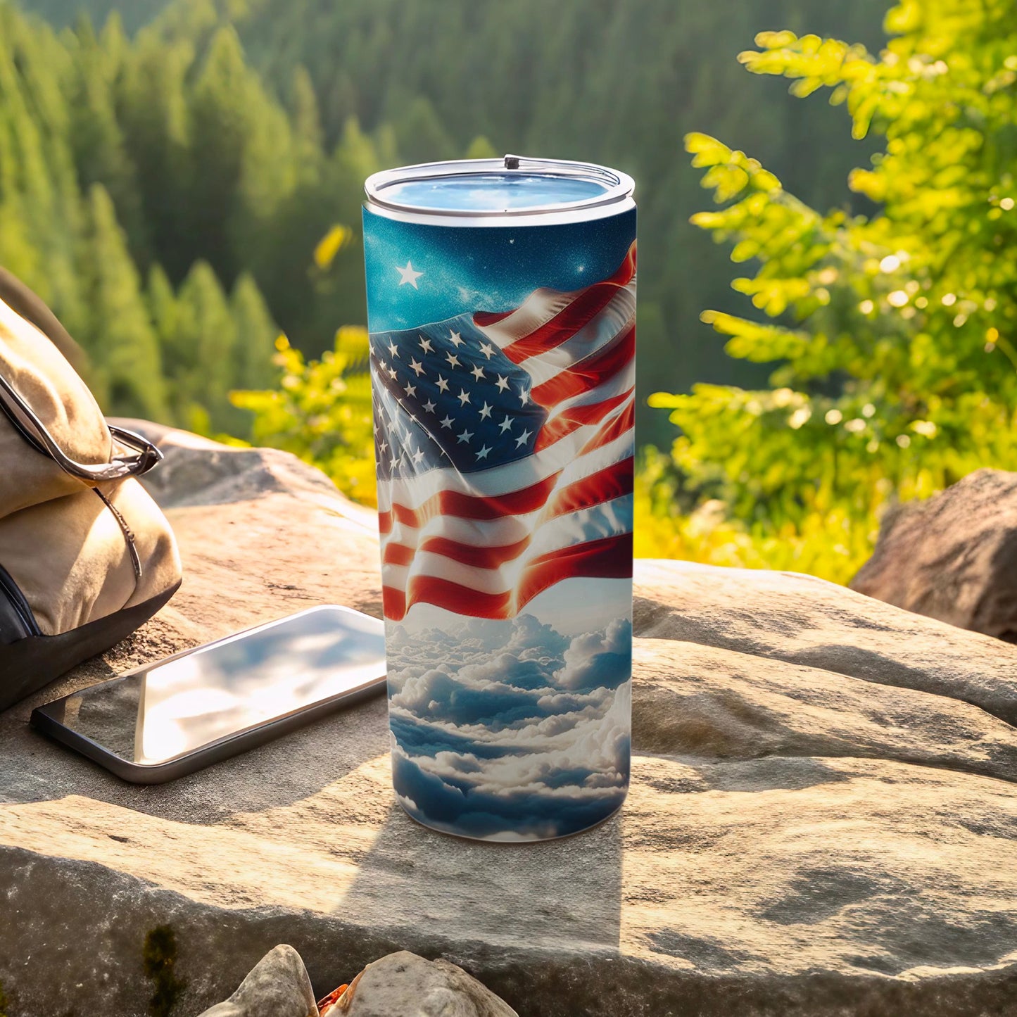American flag tumbler with starry sky and cloud design on outdoor rock.