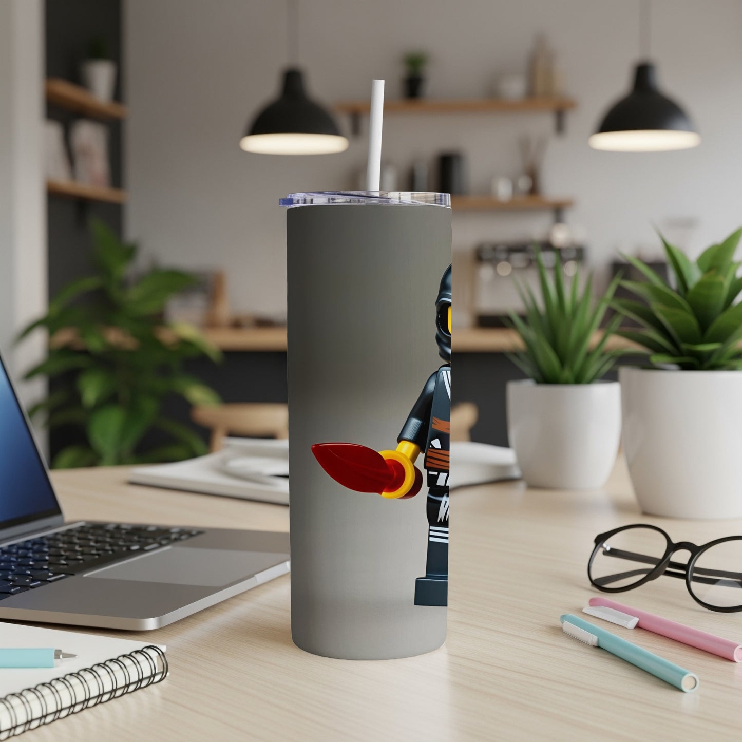 Gray tumbler with LEGO minifigure holding a red frisbee.