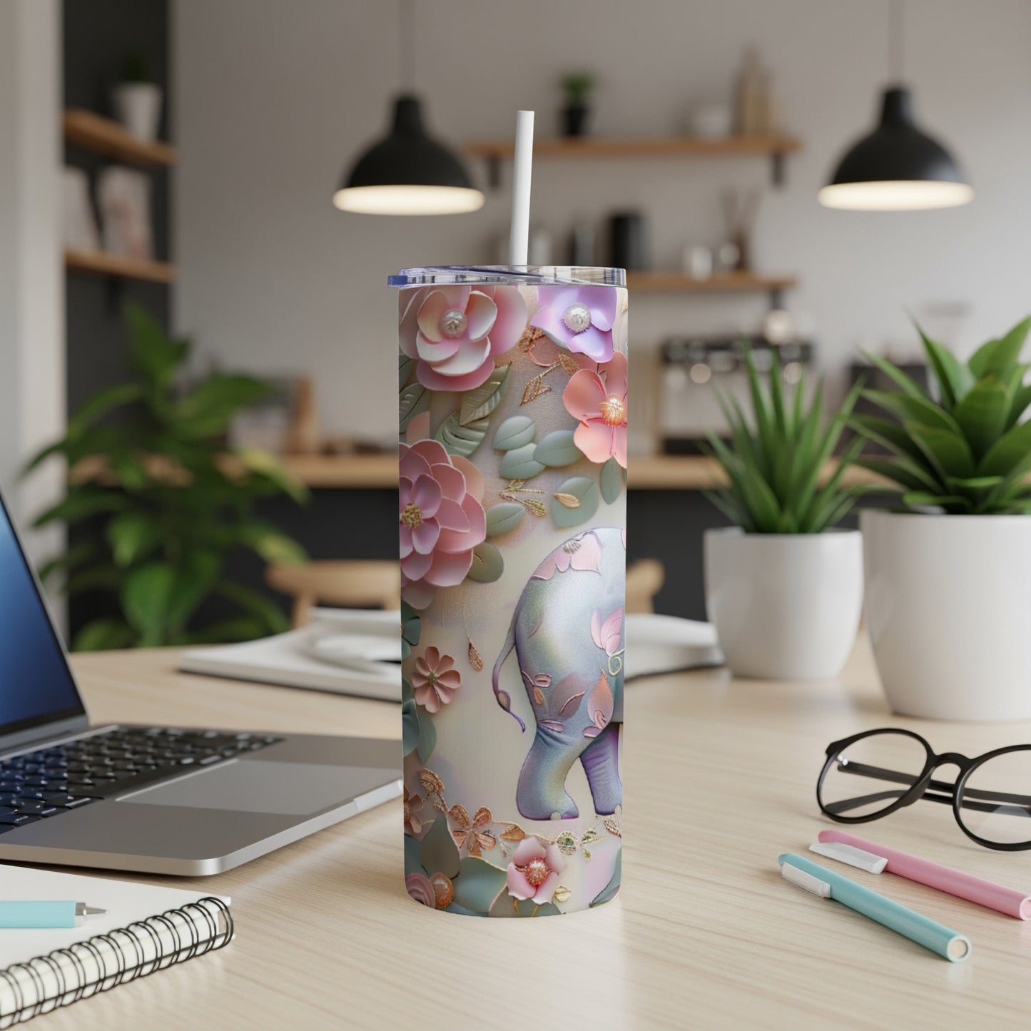 Floral elephant tumbler with straw on a desk.