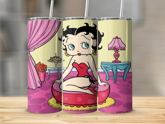 Betty Boop in a red corset sitting on a round cushion, with a lamp and table.