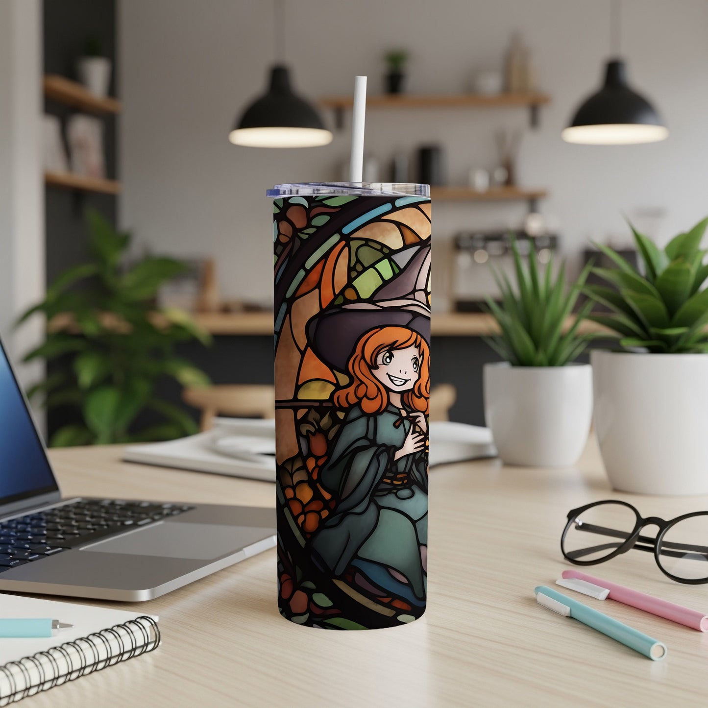 Stained glass tumbler featuring a smiling witch in an orange hat and green dress.