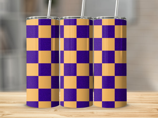 Three purple and gold checkerboard pattern tumblers with straws on a wooden surface.