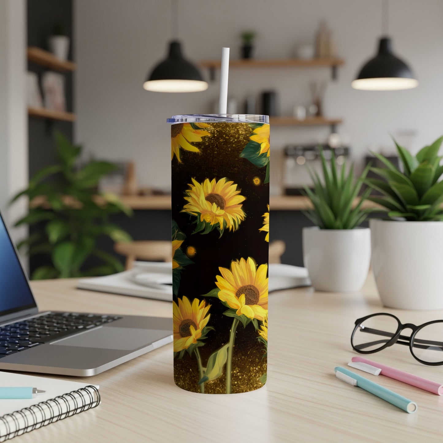 Sunflower patterned tumbler with a straw on a desk.