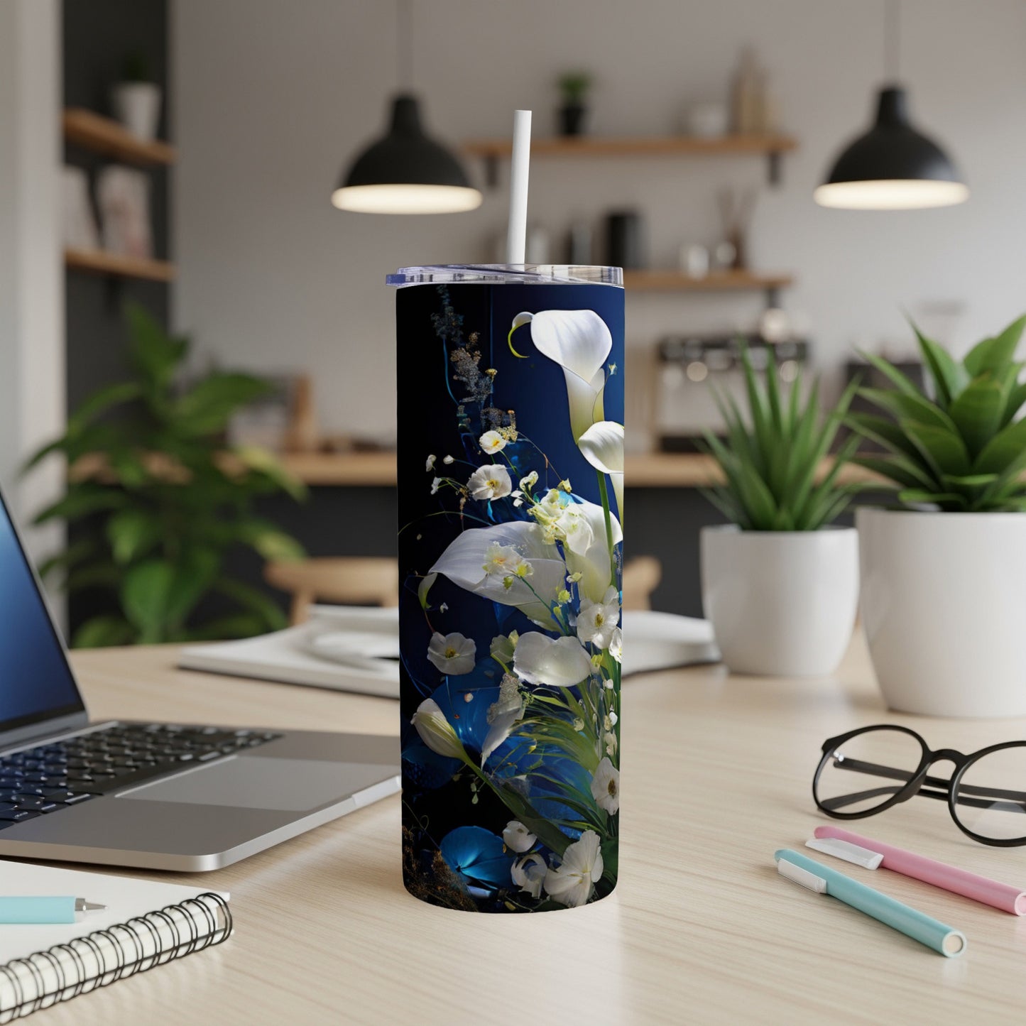 White calla lilies and greenery on a dark blue tumbler with straw.