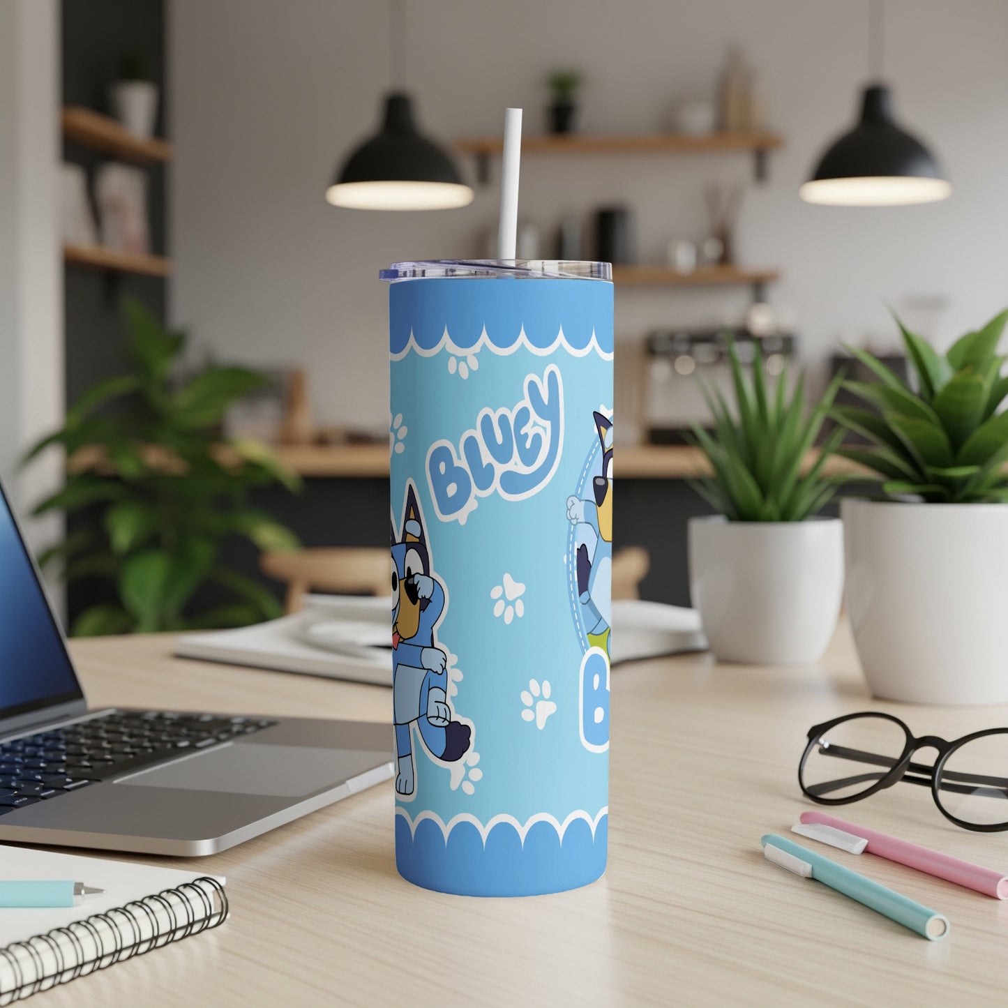 Bluey tumbler with straw on a desk with a laptop and office supplies.