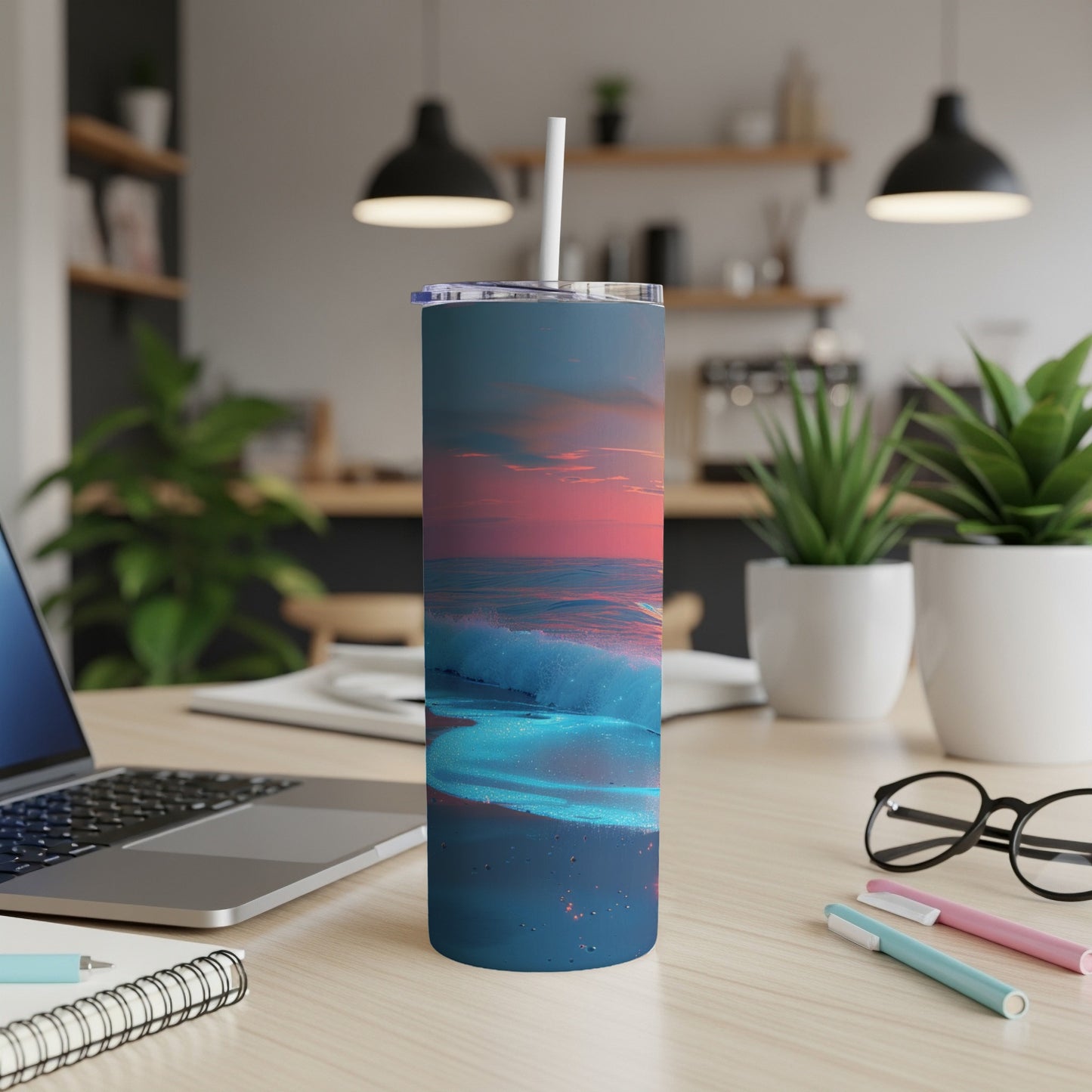 Blue and pink sunset waves on a blue tumbler, on a desk.