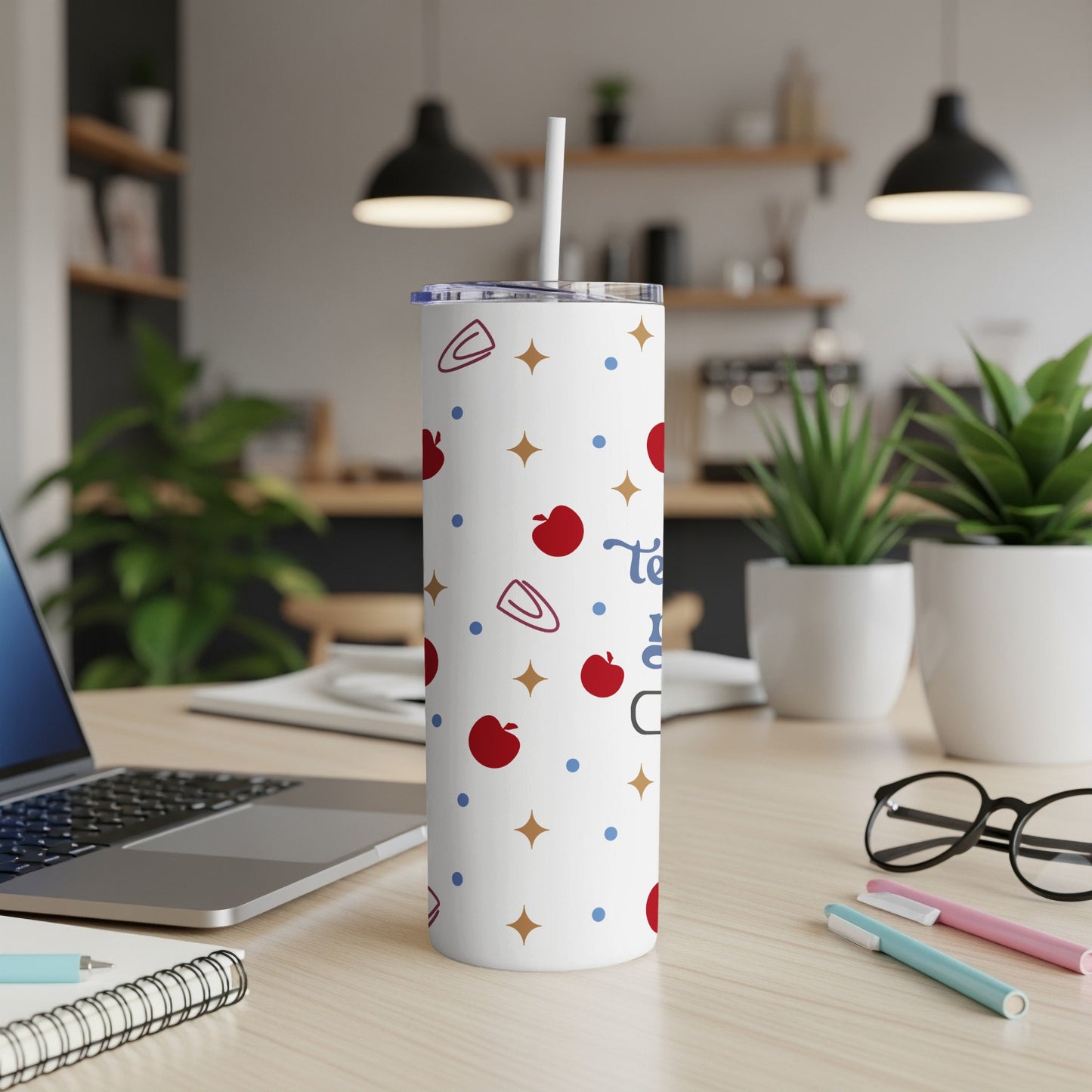 White tumbler with apples, stars, and paper clips; "Teach" text visible.