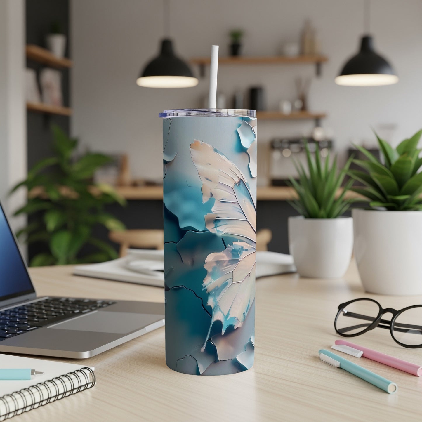 Tall tumbler with butterfly wing design, on a desk.
